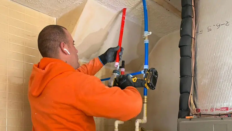 3 J's plumber running new PEX supply lines at a water heater