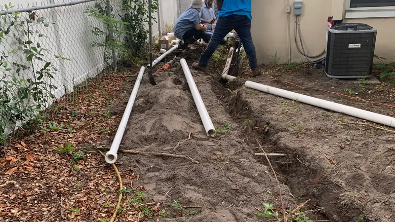 3 J's Plumbing crew trenching a yard sewer line